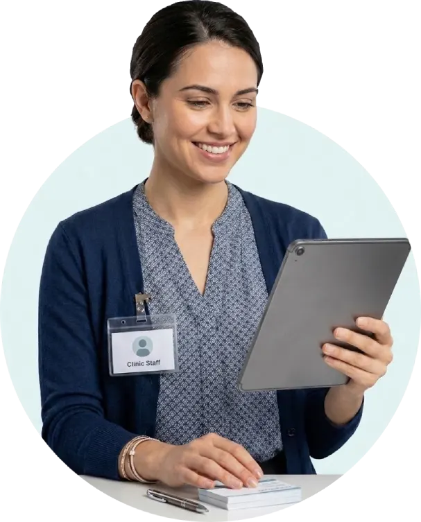 Clinic staff member using a tablet for patient records and scheduling with clinic management software India.